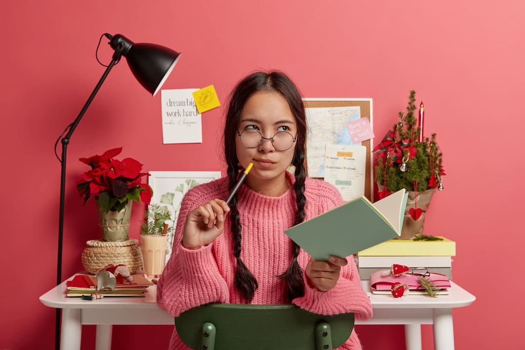 woman planning christmas with pen and notebook